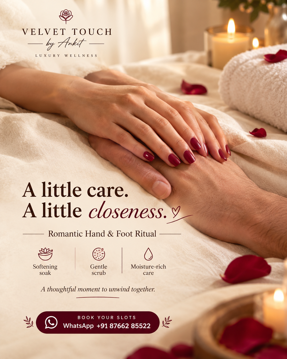 Two hands resting together on linen sheets beside a candle, rolled towel and rose petals